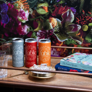 3 Fable Cocktail cans with flowers backdrop